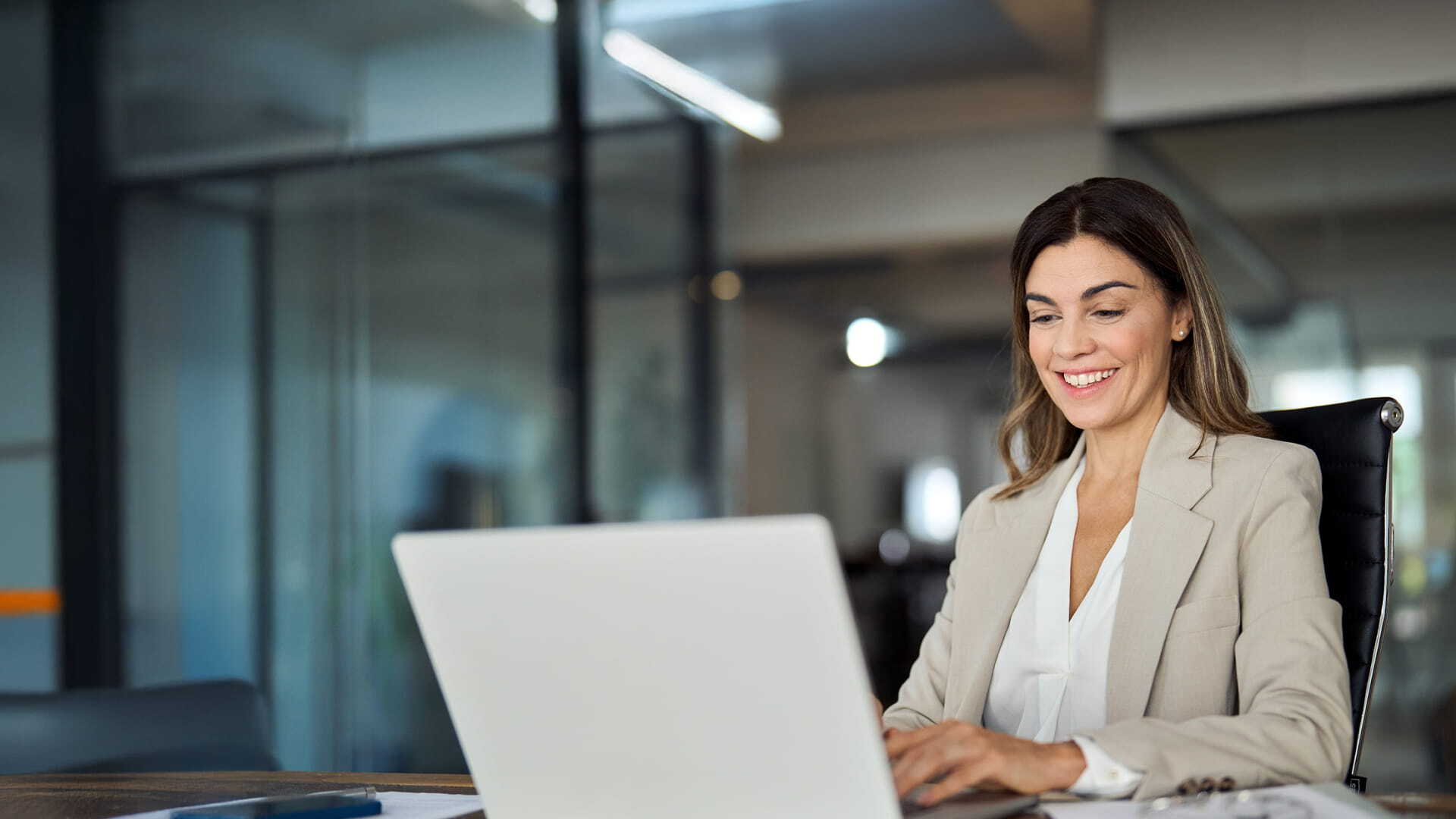 Mulher sorrindo utilizando o notebook